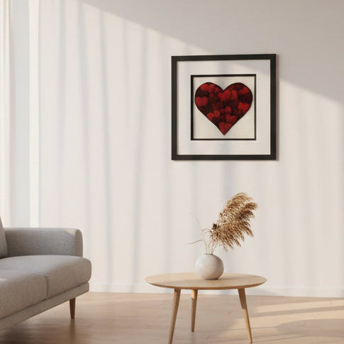 Framed artwork of a red heart on a white background