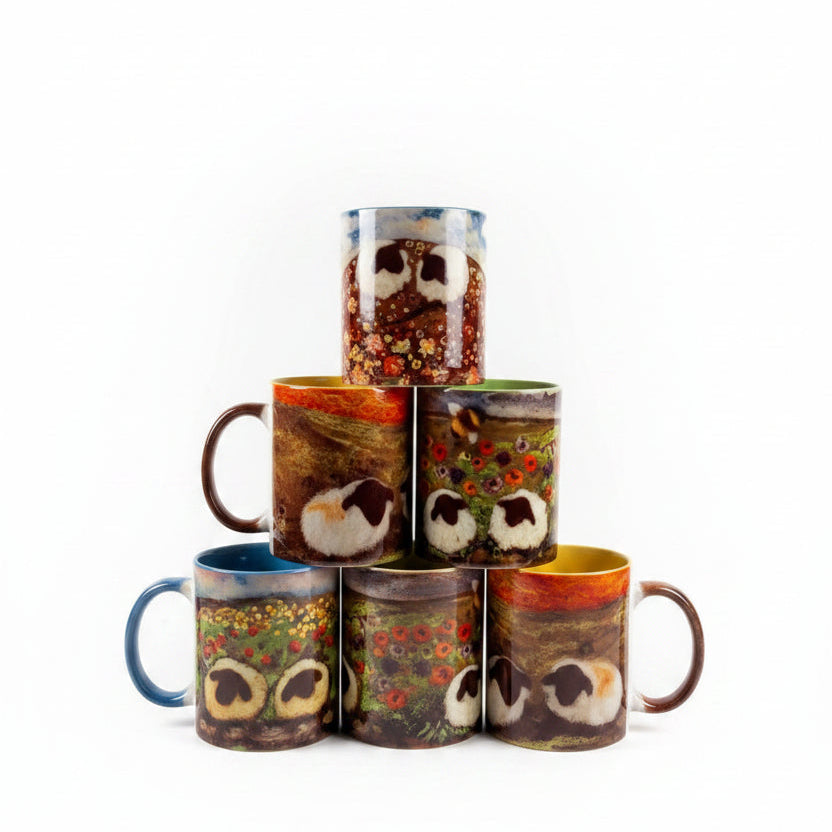 Three stacked cylindrical ceramic vases decorated with colorful owl illustrations, displayed on a white wooden tabletop next to a lit desk lamp in a home office setting.