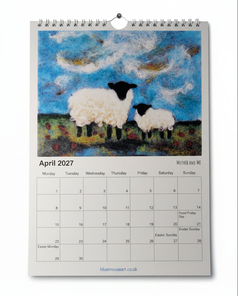 A spiral-bound March 2027 desk calendar page featuring a textured painting of two sheep under a blue cloudy sky, photographed flat on a whitewashed wooden surface.