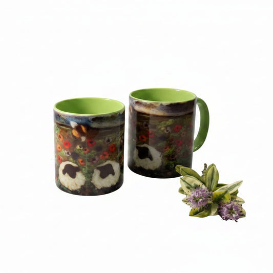 Two ceramic mugs with a detailed nature print of a bear and red flowers, featuring a bright lime green interior and handle, displayed on a rustic white wooden table next to a lamp.