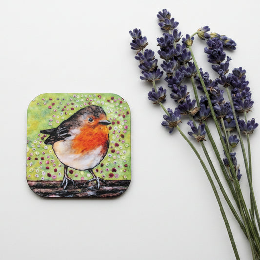 A square coaster featuring a painted robin bird on a textured green and yellow background, styled on a gray concrete surface next to sprigs of lavender.