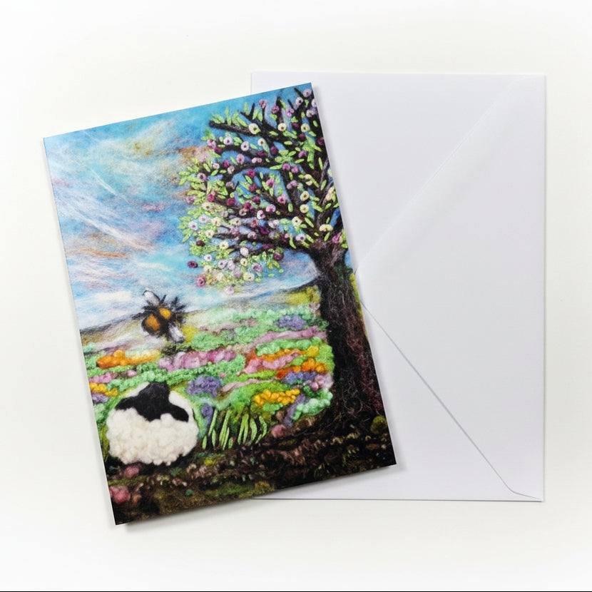 Greeting card with a landscape design featuring a sheep, flowers, and trees 