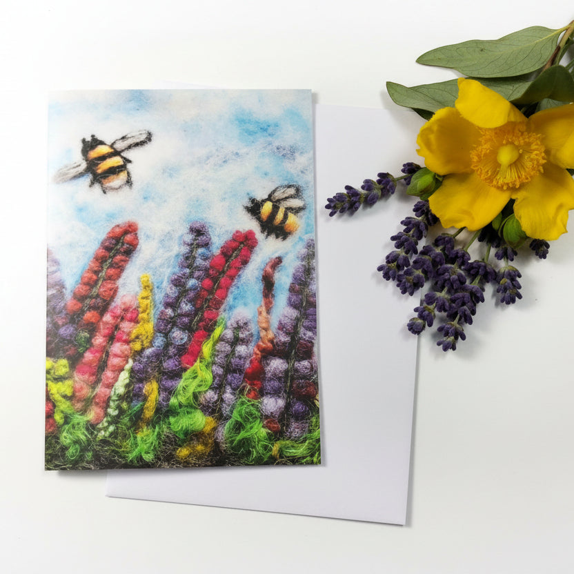 A square greeting card featuring a colorful textured painting of bumblebees flying above tall flowers in red, purple, green, and yellow, 